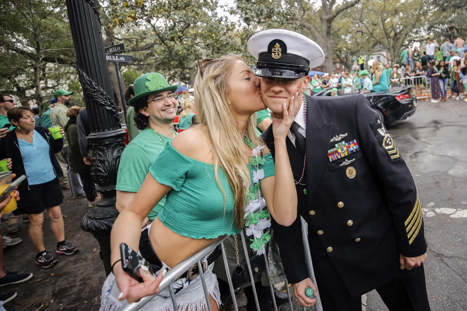 FILE - Kelsey Goran of Kennesaw, Ga., left, kisses a sailor from the USS Alaska as he marches in the 194-year-old Savannah St. Patrick's Day parade, March 17, 2018, during the St. Patrick's Day parade in Savannah, Ga. Savannah, Georgia's oldest city, is planning a supersized celebration as it marks the 200th anniversary of its beloved St. Patrick's Day parade. City Manager Jay Melder says he's expecting historic crowds for the Irish-themed parade Saturday, March 16, 2024. (AP Photo/Stephen B. Morton, file)