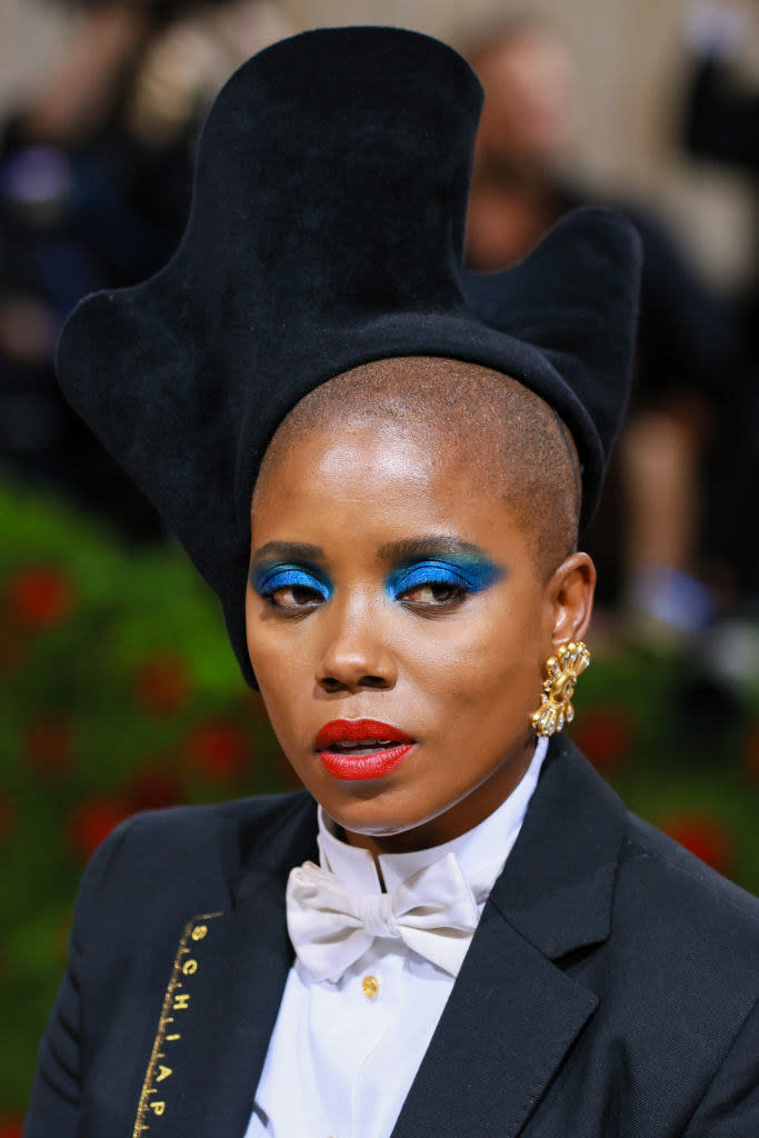 Janicza Bravo in bright blue eyeshadow and red lipstick