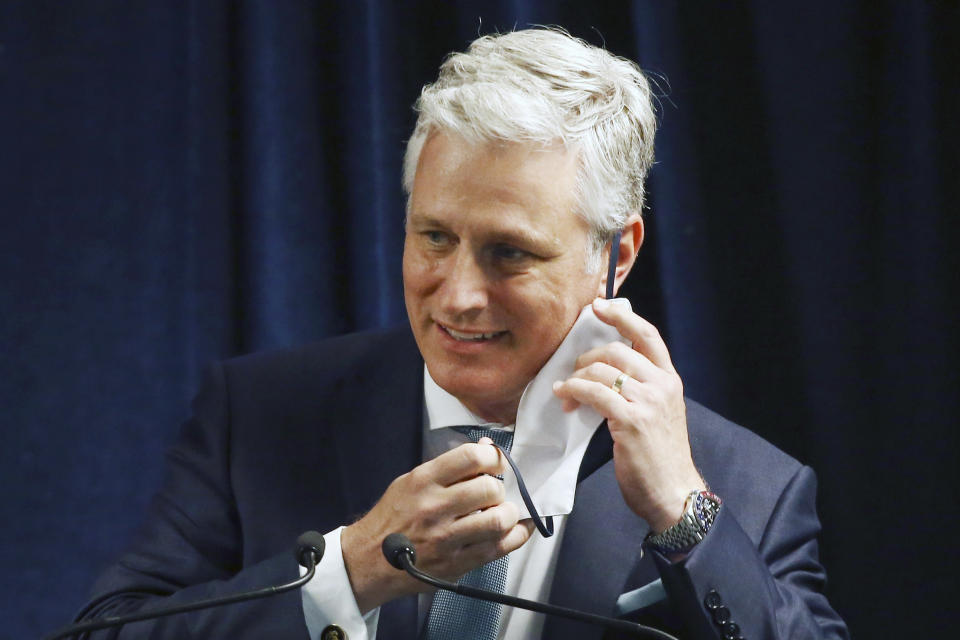 FILE - In this June 24, 2020 file photo, Robert O'Brien, assistant to the president for national security affairs, removes a face covering prior to speaking during a news conference in Phoenix. O’Brien has tested positive for the coronavirus. He’s the highest-ranking White House official to test positive so far. (AP Photo/Ross D. Franklin)