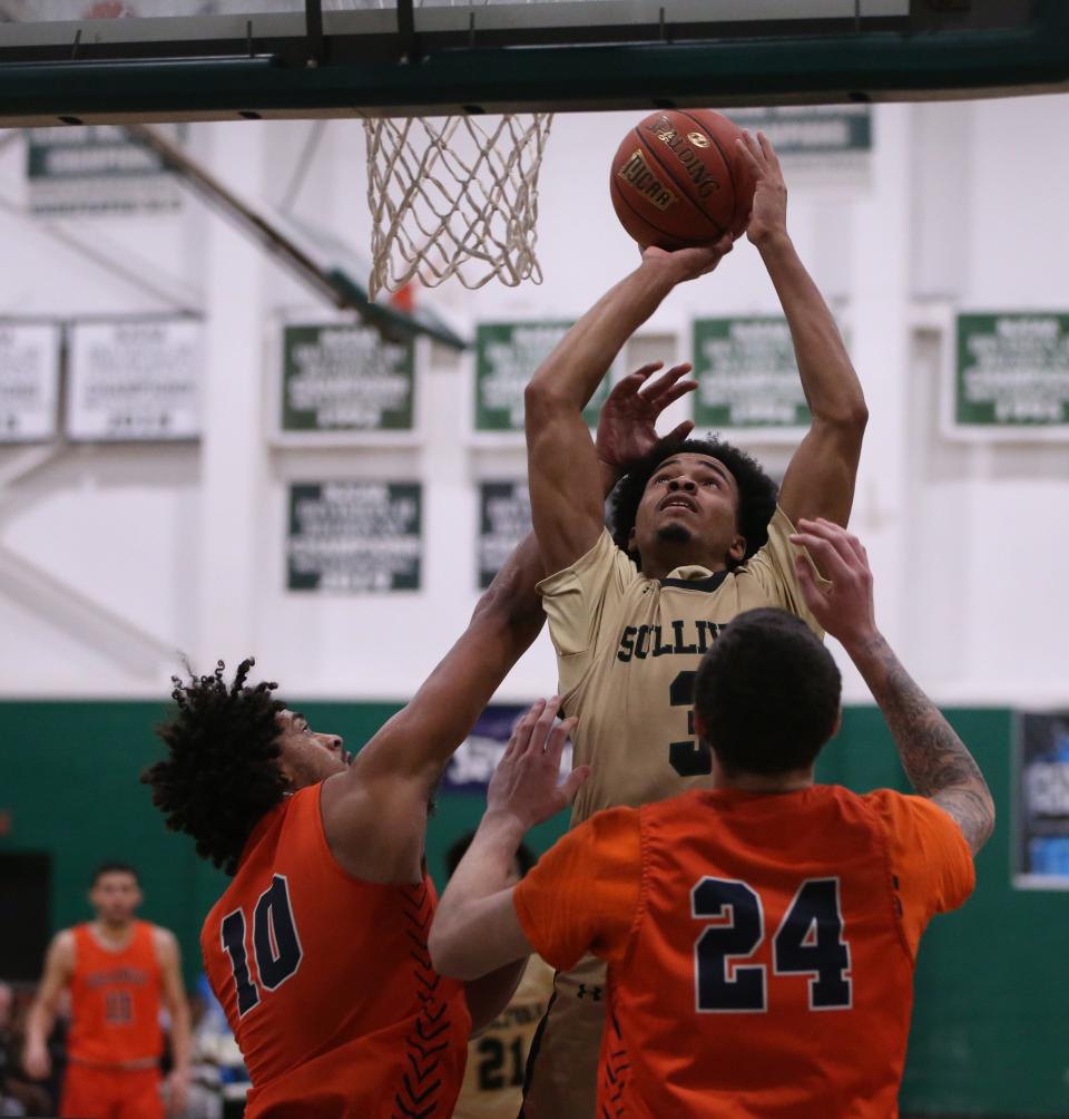 SUNY Sullivan's Cameron Gallon goes up for a shot against SUNY Orange's, from left, Romeo Aquino and George Patsalos during Tuesday's game in Loch Sheldrake on December 6, 2022.