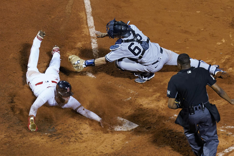 FILE - This photo by Associated Press photographer Elise Amendola shows Boston Red Sox's Alex Verdugo avoiding the tag by New York Yankees catcher Rob Brantly at home in the seventh inning of a baseball game at Fenway Park, Thursday, July 22, 2021, in Boston. Amendola, who recently retired from the AP, died Thursday, May 11, 2023, at her home in North Andover, Mass., after a 13-year battle with ovarian cancer. She was 70. (AP Photo/Elise Amendola, File)