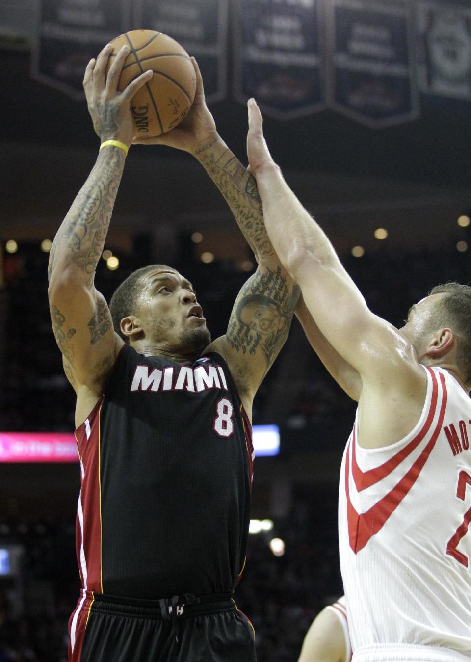 Miami Heat forward Michael Beasely (8) takes a shot over Houston Rockets forward Donatas Motiejunas (8) during the first half of an NBA basketball game, Tuesday, March, 4, 2014, in Houston. (AP Photo/Patric Schneider)