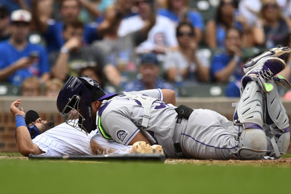 Chicago Cubs' Alfonso Rivas, , left, is tagged out at home plate by Colorado Rockies catcher Elias Diaz, right, during the fifth inning of a baseball game Saturday, Sept. 17, 2022, in Chicago. (AP Photo/Paul Beaty)