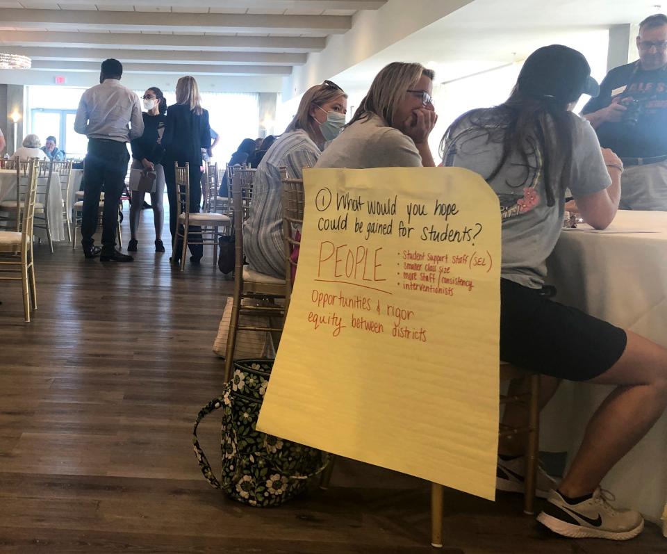 A sign hangs on a chair in June during an informational session on a proposed school district merger between Middletown and Newport.