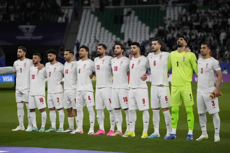 Iranian players stand for their national anthem ahead of the Asian Cup Group C soccer match between Iran and Palestine at the Education City Stadium in Al Rayyan, Qatar, Sunday, Jan. 14, 2024. (AP Photo/Aijaz Rahi)