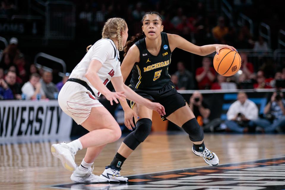 Michigan guard Laila Phelia brings the ball up court near Louisville guard Hailey Van Lith during the third quarter in the Wichita regional finals of the women's college basketball NCAA Tournament March 28, 2022 at INTRUST Bank Arena.