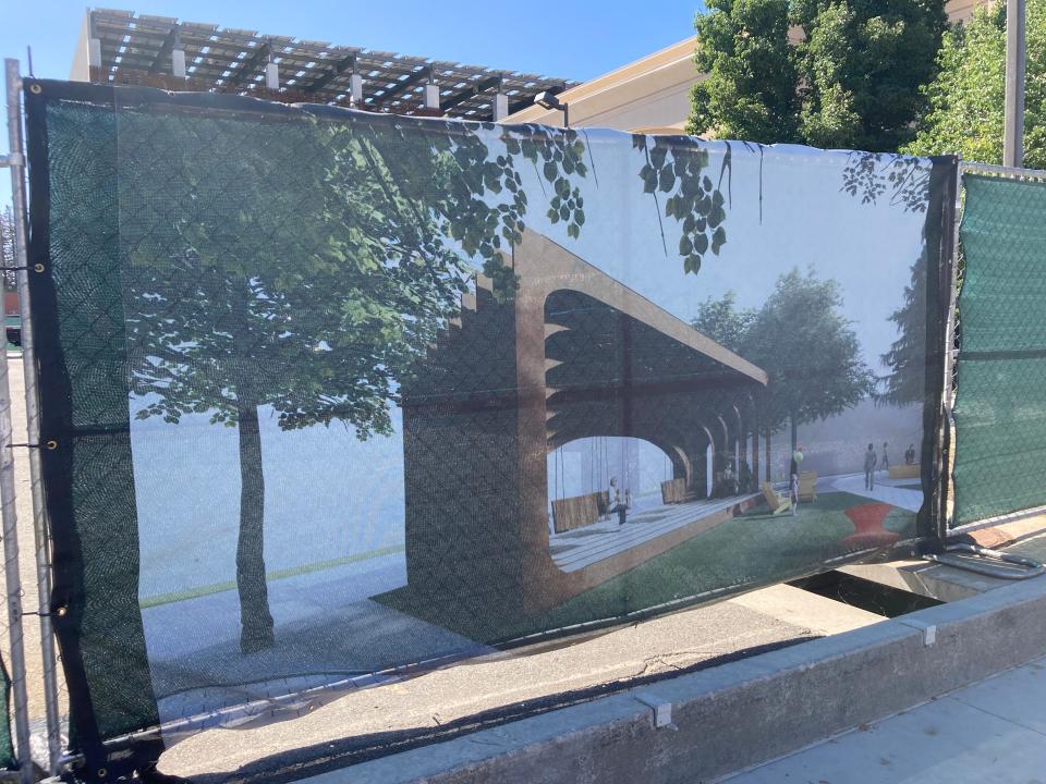 An artist rendering of Whistle Stop Park is attached to the fence that surrounds the area where the park will be built in downtown Redding.