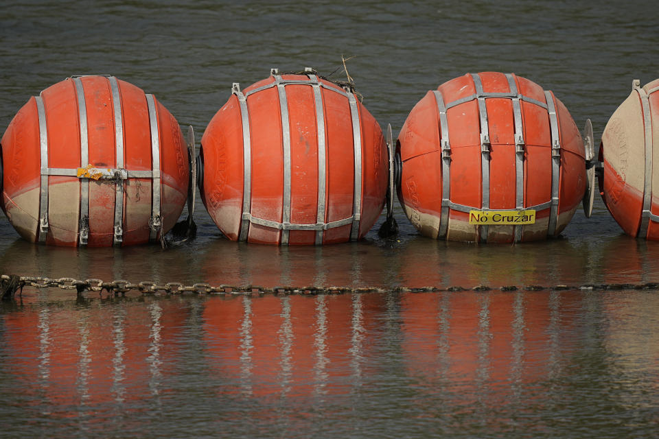 Buoys being used as a barrier are chained along the center of the Rio Grande, Monday, Aug. 21, 2023, in Eagle Pass, Texas. (AP Photo/Eric Gay)