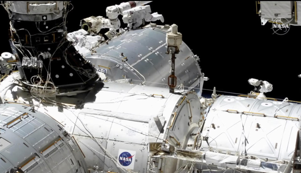 In this image taken from NASA video, NASA astronauts Mike Hopkins, center right, and Victor Glover, center left, work outside the International Space Station’s European lab on Wednesday, Jan. 27, 2021. The duo went spacewalking Wednesday to install a high-speed data link outside the lab. (NASA via AP)