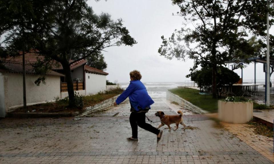 A woman walks her dog near the sea near tAmaliada.