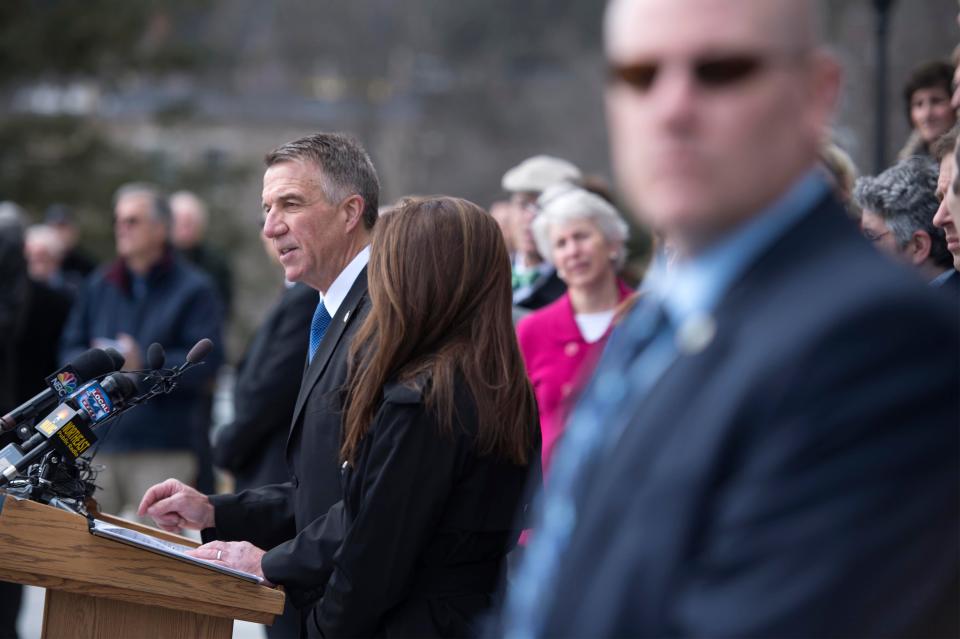 One of several Vermont State Police officers present, right, stands guard as Gov. Phil Scott speaks before signing three gun reform bills on the steps of the Statehouse in Montpelier on Wednesday , April 11, 2018.