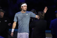 Greece's Stefanos Tsitsipas waves supporters as he leaves the pitch after injuring during the singles tennis match against Denmark's Holger Rune, of the ATP World Tour Finals at the Pala Alpitour, in Turin, Italy, Tuesday, Nov. 14, 2023. (AP Photo/Antonio Calanni)