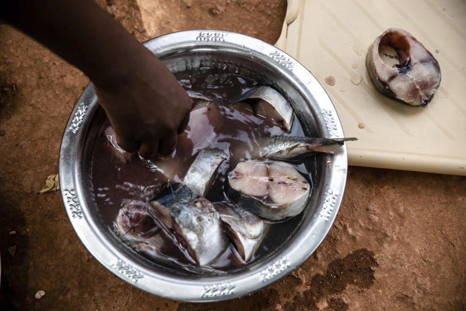 Mariama Sawadogo, 44, who works as a radio host at Zama Radio, prepares lunch at her home in Kaya, Burkina Faso, Monday, Oct. 25, 2021. Many guests and listeners in Burkina Faso call her "aunty" as she gently guides them to the right answers and awards prizes such as soap and washing buckets. In the West African country of Burkina Faso, many feel the government has let them down during the pandemic. Tests, vaccines and messaging often miss many residents, despite a $200 million budget for virus-response efforts. In a region where women are responsible for family work and community relationships, they’ve stepped up to fill in gaps. (AP Photo/Sophie Garcia)