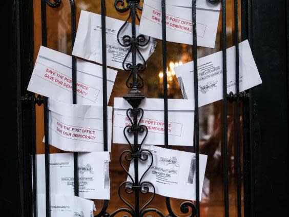 Demonstrators gather outside of the condo of President Donald Trump donor and current U.S. Postmaster General Louis Dejoy on Saturday in DC (Getty Images)