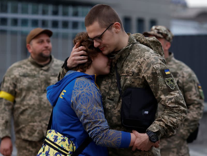 Couple hugs before frontline deployment at train station in Kyiv