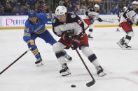 Columbus Blue Jackets' Alexandre Texier (42) battles for the puck against St. Louis Blues' Dakota Joshua (54) during the second period of an NHL hockey game Saturday, Nov. 27, 2021, in St. Louis. (AP Photo/Michael Thomas)