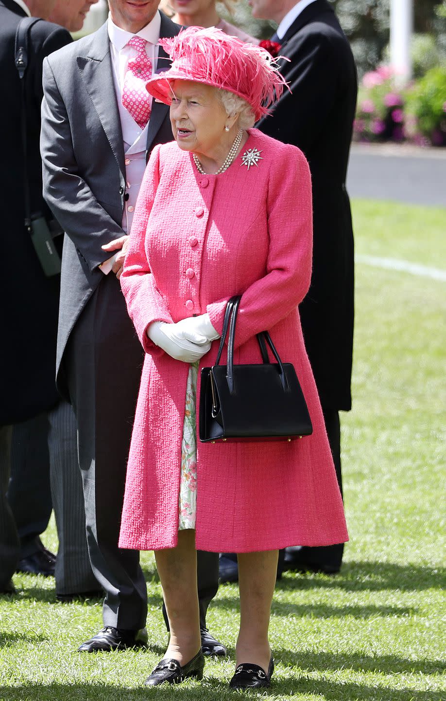 <p>Here's a full-length look at the Queen's outfit today, the vibrant shade is a departure from the blue hues she chose earlier this week. </p>