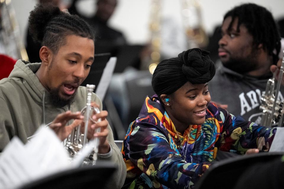 Makhi Smith, left, laughs with Ashantae Gary during practice Tuesday for the Wilberforce Hounds of Sound marching band. Originally a cellist in her high school orchestra, Gary said that marching band allowed her to continue to be a musician after the cost of playing in an orchestra became prohibitive.