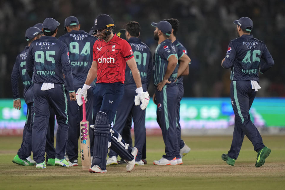 England's Dawid Malan, center, walks off the field after losing his wicket during the first T20 cricket match between Pakistan and England, in Karachi, Pakistan, Tuesday, Sept. 20, 2022. (AP Photo/Anjum Naveed)