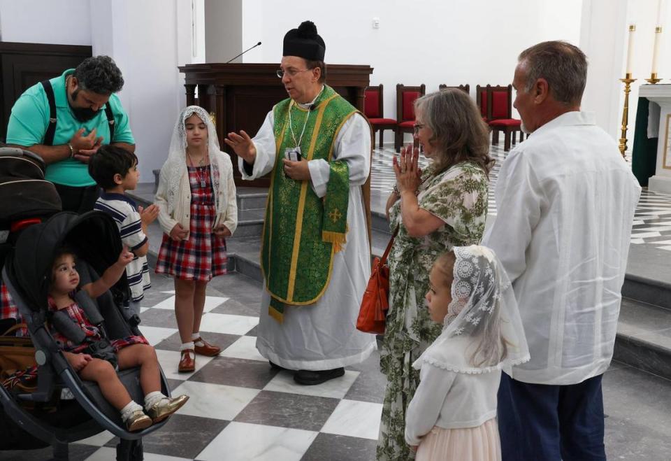 Monsignor Oscar Castañeda, center, blesses Antonio Simon, Jr., left, and his family after the Traditional Latin Mass service at Our Lady of Belen Chapel, Sunday, July 30, 2023.