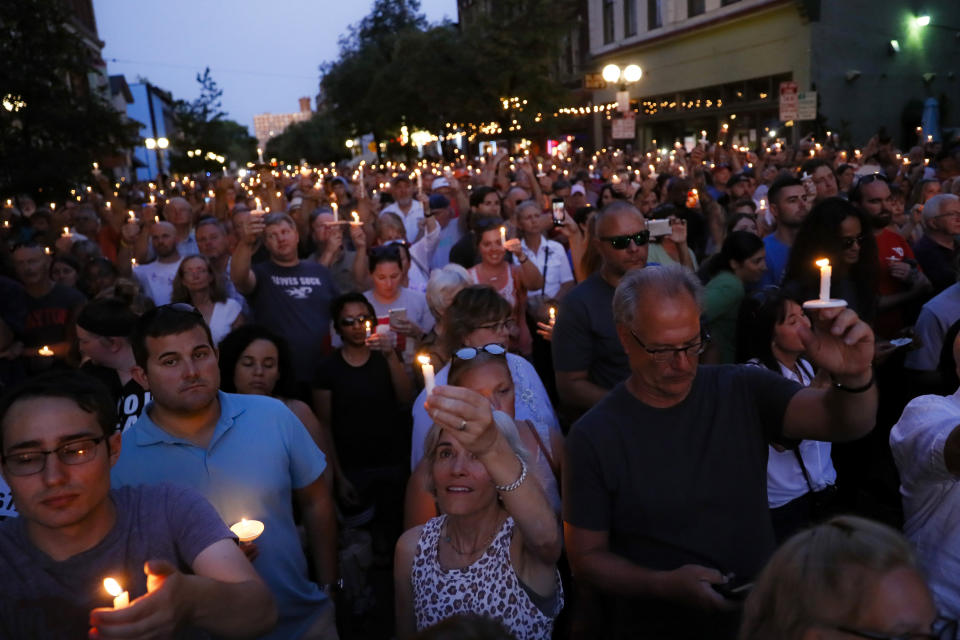 Mourners gather for a vigil at the scene of a mass shooting, Sunday, Aug. 4, 2019, in Dayton, Ohio. Multiple people in Ohio were killed in the second mass shooting in the U.S. in less than 24 hours. (AP Photo/John Minchillo)