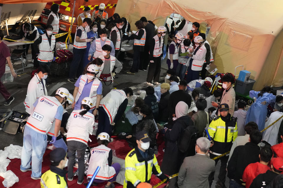 FILE - Rescue workers treat injured people on a street near the scene of a crush in Seoul, South Korea, on Oct. 30, 2022. South Korea’s parliament on Thursday, May 2, 2024 approved legislation mandating a new, independent investigation into the 2022 Halloween crush in Seoul that killed 159 people. (AP Photo/Lee Jin-man, File)