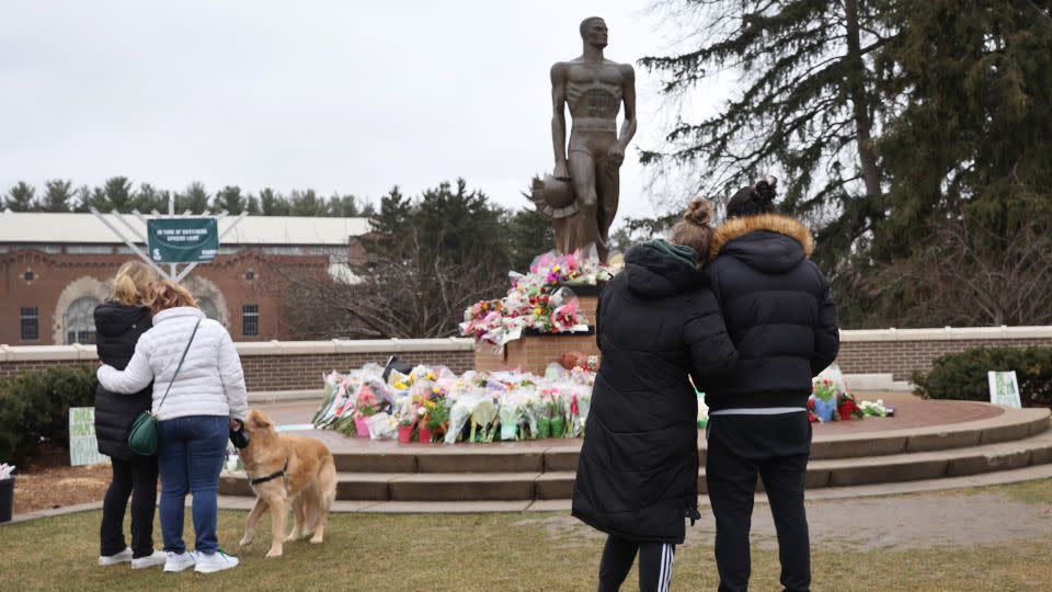 Flowers are laid at the base of the spartan statue on the campus of Michigan State University as a tribute to the students killed and wounded in a shooting. - Scott Olson/Getty Images