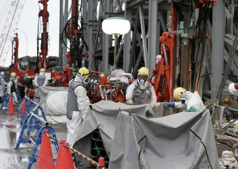 Workers construct an ice wall at the tsunami-crippled Fukushima nuclear power plant in Okuma, Fukushima Prefecture, on July 9, 2014