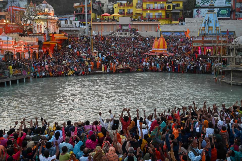 TOPSHOT - Hindu devotees attend evening prayers after taking a holy dip in the waters of the River Ganges on the Shahi Snan (grand bath) on the occasion of the Maha Shivratri festival during the ongoing religious Kumbh Mela festival in Haridwar on March 11, 2021. (Photo by Prakash SINGH / AFP) (Photo by PRAKASH SINGH/AFP via Getty Images)