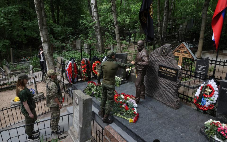 People queue to approach the sculpture of Yevgeny Prigozhin