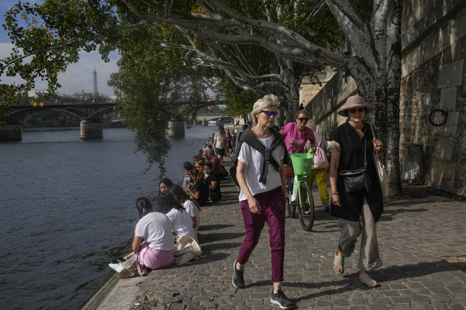 FILE - People walk along the Seine River, Oct. 2, 2023, in Paris where temperatures rose. October was the fifth straight month that Earth set a record for the hottest month in recorded history. (AP Photo/Michel Euler, File)