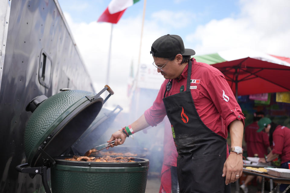 Arturo Gutierrez, of the Sociedad Mexicana de Parrilleros team, cooks at the World Championship Barbecue Cooking Contest, Friday, May 17, 2024, in Memphis, Tenn. (AP Photo/George Walker IV)