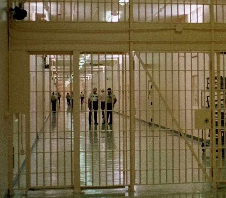 Corrections officers, center, keep a watchful eye down a main access corridor at Florida State Prison.