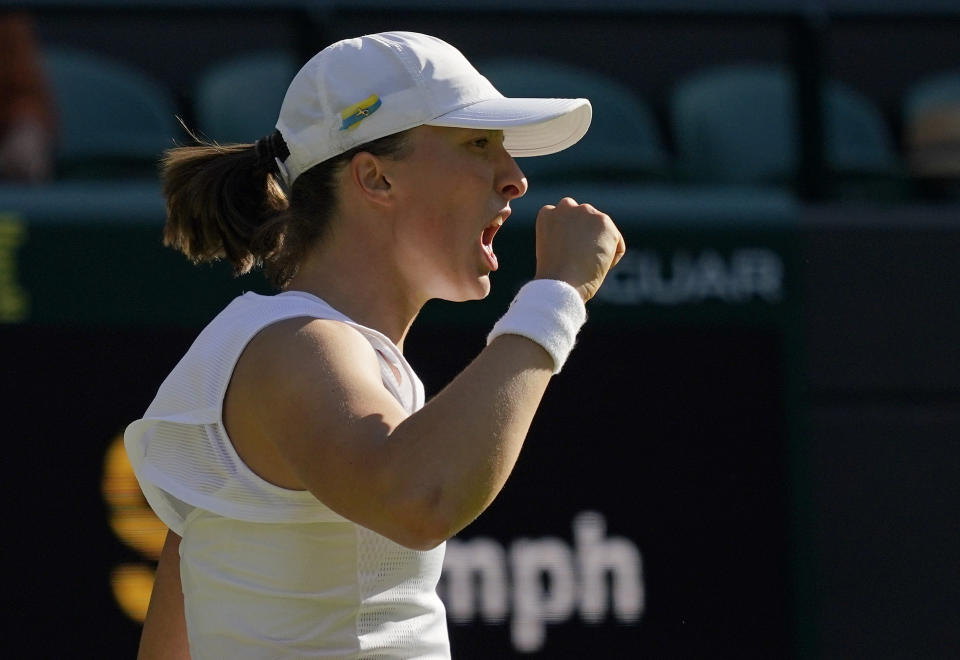 Poland's Iga Swiatek celebrates winning a point against Lesley Pattinama Kerkhove of the Netherlands in a second round women's singles match on day four of the Wimbledon tennis championships in London, Thursday, June 30, 2022. (AP Photo/Alberto Pezzali)
