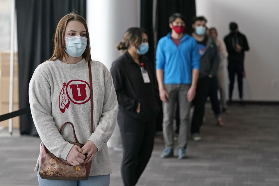 University of Utah student Abigail Shull waits in line before taking a rapid COVID-19 test at the University of Utah student testing site Wednesday, Nov. 18, 2020, in Salt Lake City. As college students prepare to go home for the holidays, some schools are quickly ramping up COVID-19 testing to try to keep infections from spreading further as the coronavirus surges across the U.S. (AP Photo/Rick Bowmer)