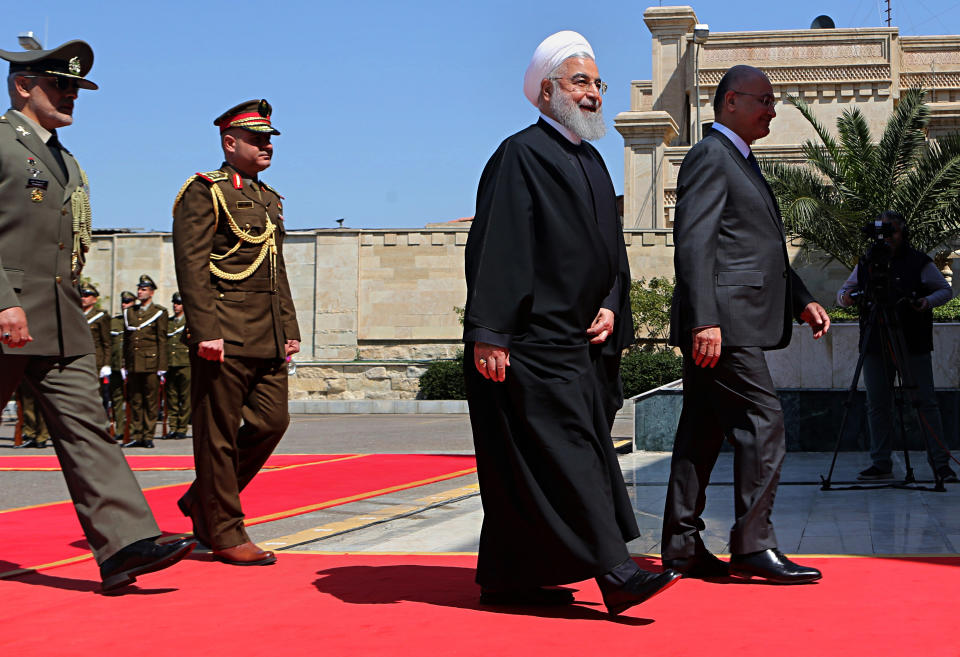 Iranian President Hassan Rouhani, center, walks with Iraqi President Barham Salih, before their meeting at Salam Palace in Baghdad, Iraq, Monday, March 11, 2019. Rouhani is visiting Iraq, seeking to boost ties between the two neighboring states and possibly secure Iraq’s help in bypassing U.S. sanctions the Trump administration re-imposed last year. (AP Photo/Khalid Mohammed)