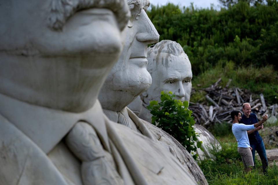 People pose for a selfie while touring the decaying remains of salvaged busts of former US Presidents on August 25, 2019, in Williamsburg, Virginia. (Photo: Brendan Smialowski/AFP/Getty Images)