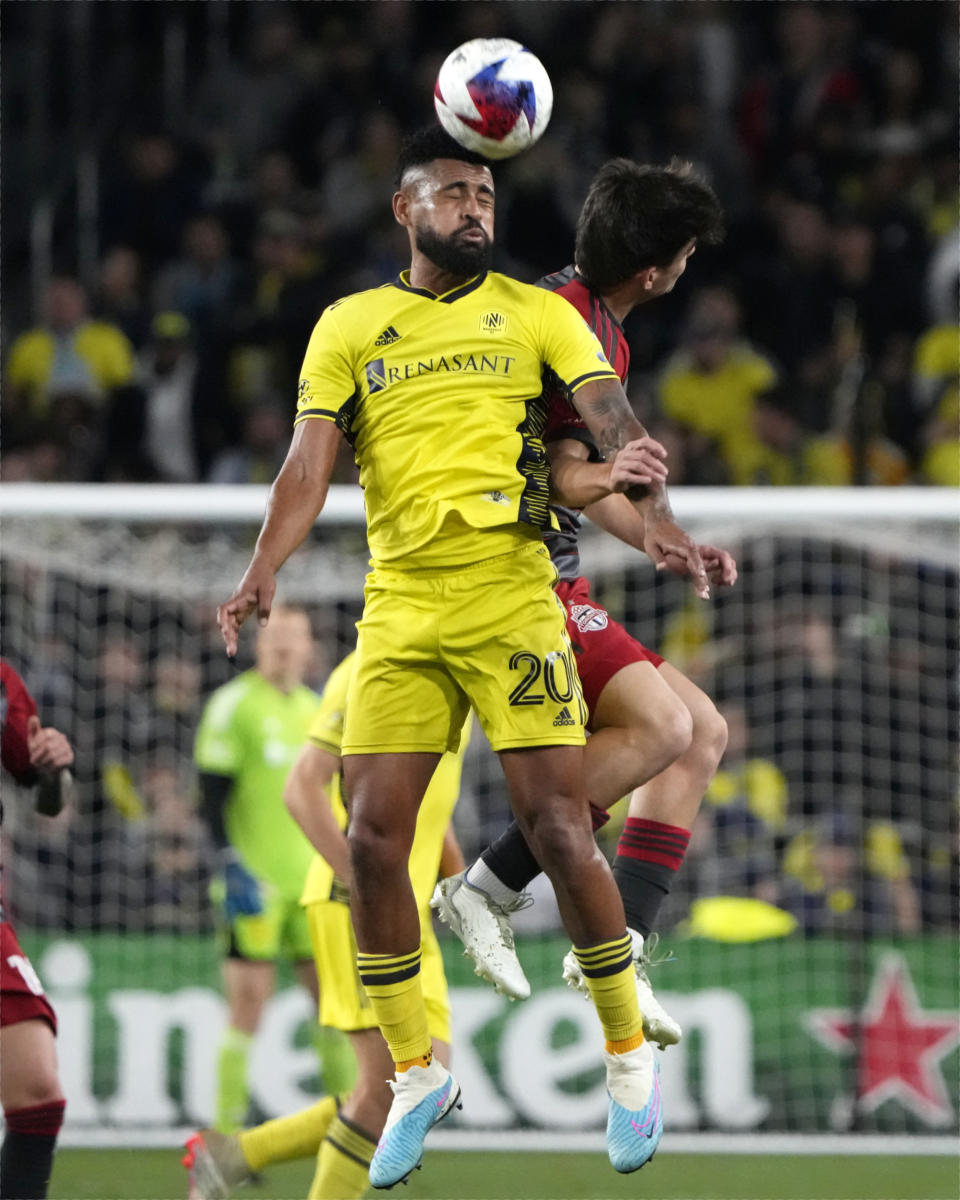 Nashville SC's Anibal Godoy (20) and Toronto FC's Alonso Coello go for a head ball during the second half of an MLS soccer match Saturday, April 8, 2023, in Nashville, Tenn. (AP Photo/Mark Humphrey)