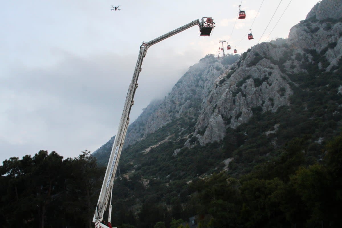 A rescue team work with passengers of a cable car transportation systems outside Antalya, southern Turkey (AP)