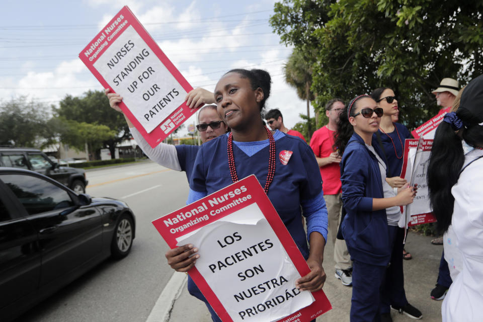 Nurse Alexandra Rene carries a sign reading "Patients are our Priority" during a one-day strike outside of Palmetto General Hospital, Friday, Sept. 20, 2019, in Hialeah, Fla. Registered nurses staged a one-day strike against Tenet Health hospitals in Florida, California and Arizona on Friday, demanding higher wages and better working conditions. (AP Photo/Lynne Sladky)