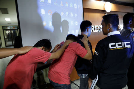 Suspects arrested for cyber-crime related hoaxes on social media are led into a National Police Cyber Crime press conference in Jakarta, Indonesia February 28, 2018. Picture taken February 28, 2018. REUTERS/Darren Whiteside