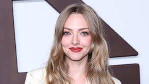 Amanda Seyfried Looking at camera Smiling wearing cream colored blazer and matching top