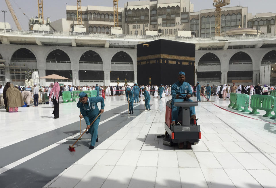 Workers clean the Grand Mosque, during the minor pilgrimage, known as Umrah, in the Muslim holy city of Mecca, Saudi Arabia, Monday, March 2, 2020. At Islam’s holiest site in Mecca, restrictions put in place by Saudi Arabia to halt the spread of the new coronavirus saw far smaller crowds than usual on Monday. (AP Photo/Amr Nabil)