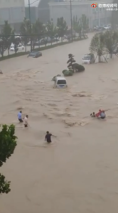 民眾直接在路上被大水沖走，附近民眾趕緊救援。   圖：翻攝微博