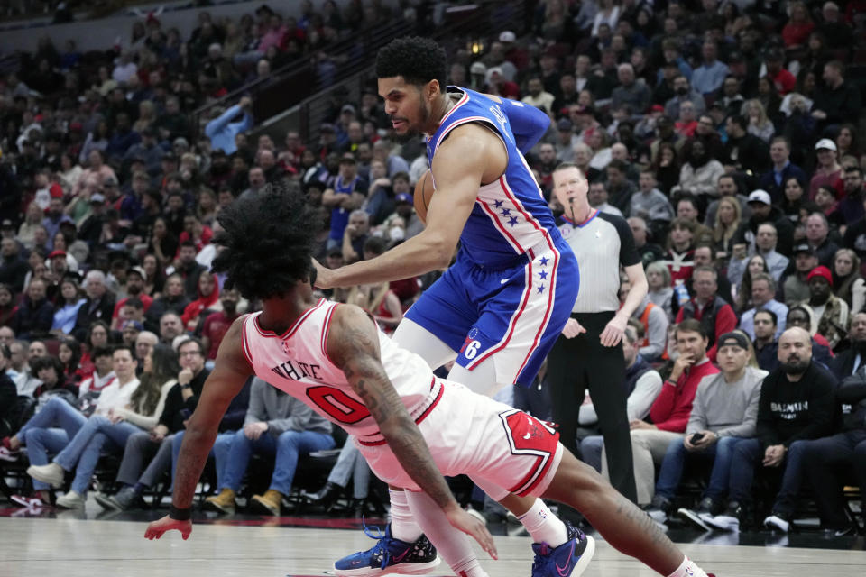 Chicago Bulls' Coby White takes the charge from Philadelphia 76ers' Tobias Harris during the first half of an NBA basketball game Wednesday, March 22, 2023, in Chicago. (AP Photo/Charles Rex Arbogast)