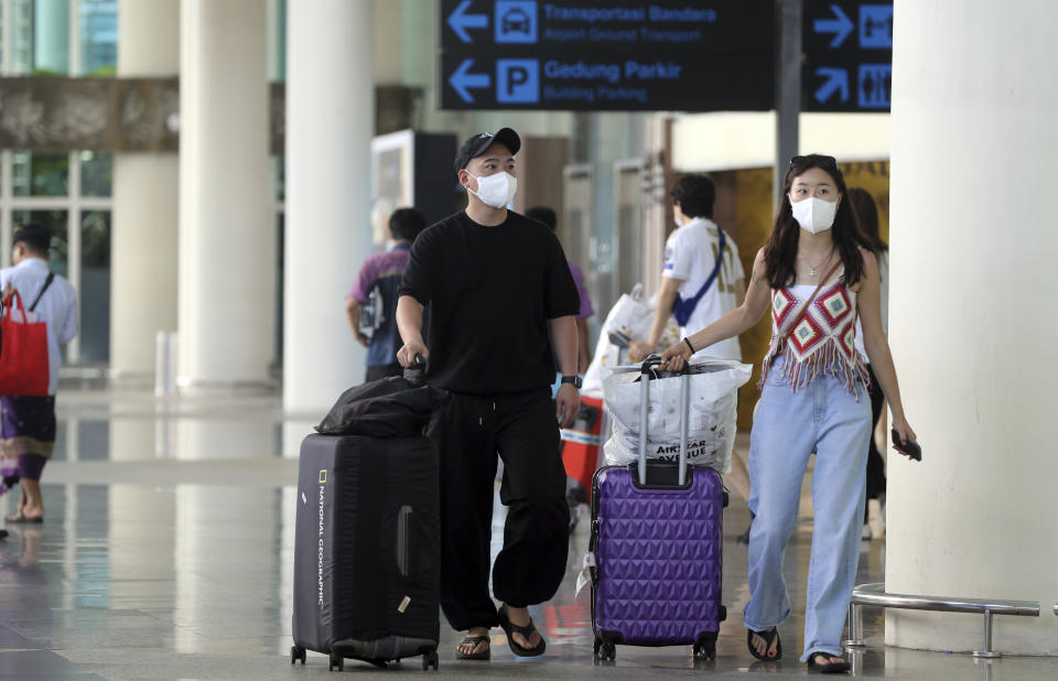 Chinese tourists carry their luggage on their arrival at the Ngurah Rai international airport in Bali, Indonesia on Sunday, Jan. 22, 2023. A direct flight from China landed in Indonesia’s resort island of Bali for the first time on Sunday in nearly three years after the route was suspended due to the pandemic. (AP Photo/Firdia Lisnawati)