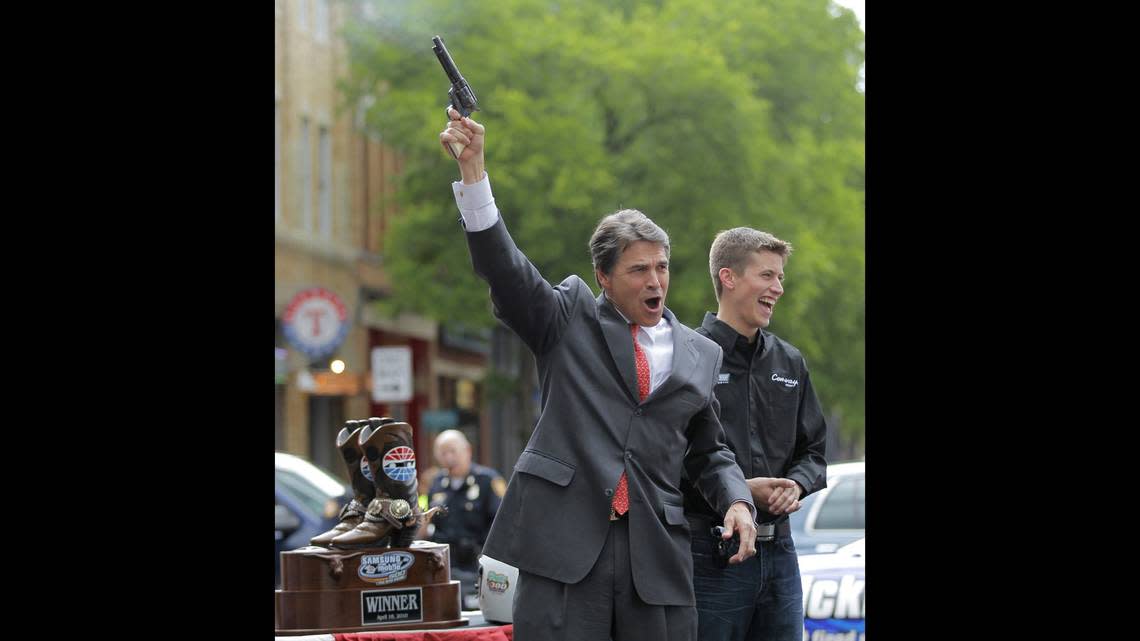 In 2010, Gov. Rick Perry has some fun with a six shooter filled with blanks as NASCAR driver Colin Braun looked on at an event in downtown Fort Worth to kickoff a weekend of NASCAR racing at the Texas Motor Speedway. (Star-Telegram file photo)