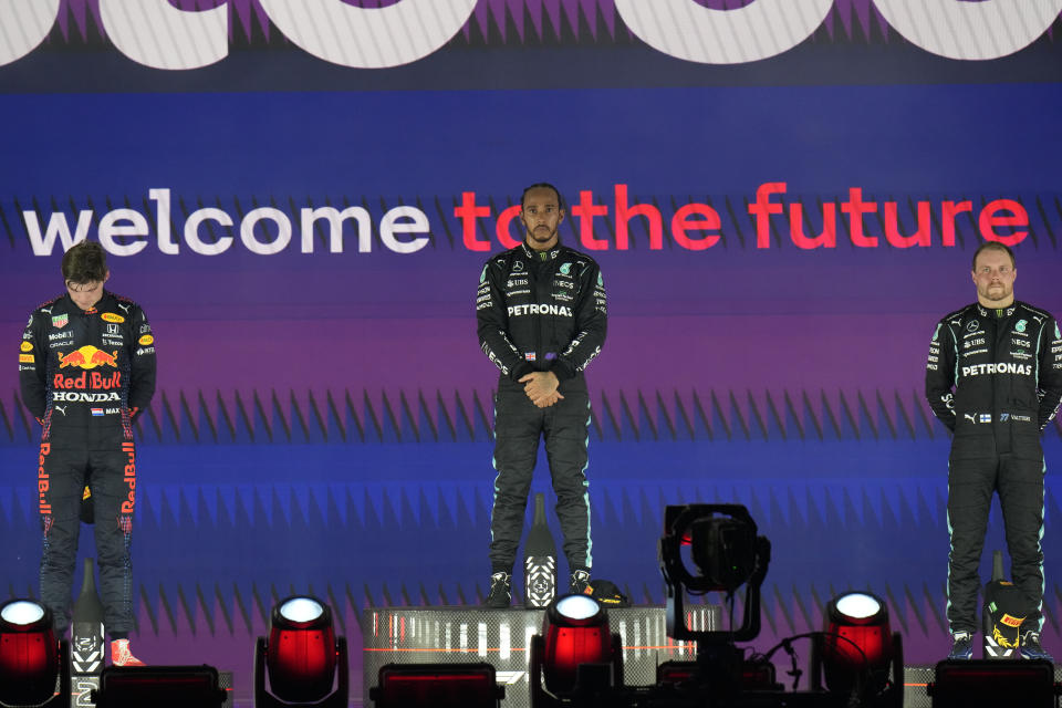 Mercedes driver Lewis Hamilton of Britain stand at the podium after winning the Formula One Saudi Arabian Grand Prix in Jiddah, Sunday, Dec. 5, 2021. Left is second placed Red Bull driver Max Verstappen of the Netherlands and Ron the right is third, Mercedes driver Valtteri Bottas of Finland. (AP Photo/Hassan Ammar)