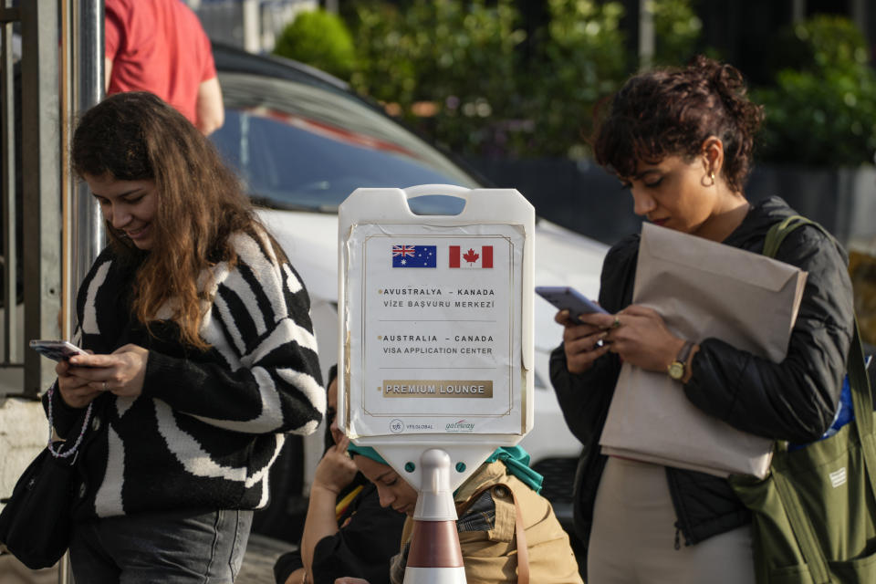 People wait for their turn at a visa application center in Istanbul, Friday, Nov. 3, 2023. Turkey is marking its centennial but a brain drain is casting a shadow on the occasion. Government statistics indicate that a growing number of the young and educated are looking to move abroad in hopes of a better life, mainly in Europe. (AP Photo/Emrah Gurel)