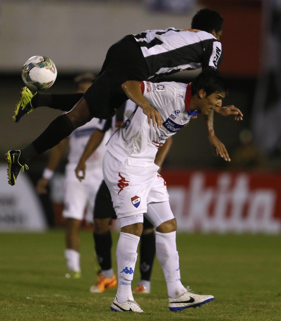 Jo (top) of Brazil's Atletico Mineiro fights for the ball with Angel Almiron of Paraguay's Nacional during their Copa Libertadores soccer match in Ciudad del Este March 12, 2014. REUTERS/Jorge Adorno (PARAGUAY - Tags: SPORT SOCCER)
